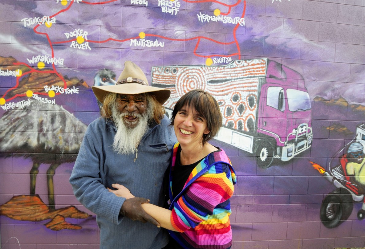 The Purple House which runs dialysis for indigenous people who live in remote areas has been nominated for the Pride of Australia Award. Patient Patrick Tjungarryi and Purple House Manager  Sarah Brown  enjoy a laugh in front of a mural that backs onto The Purple House