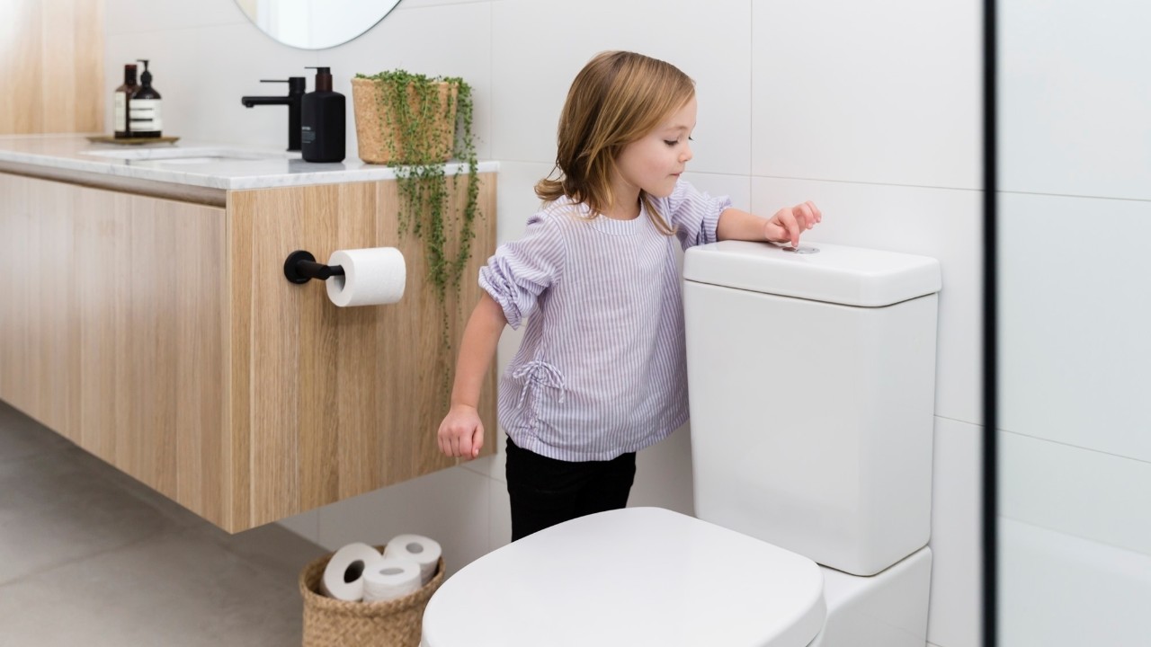 Girl flushing the toilet