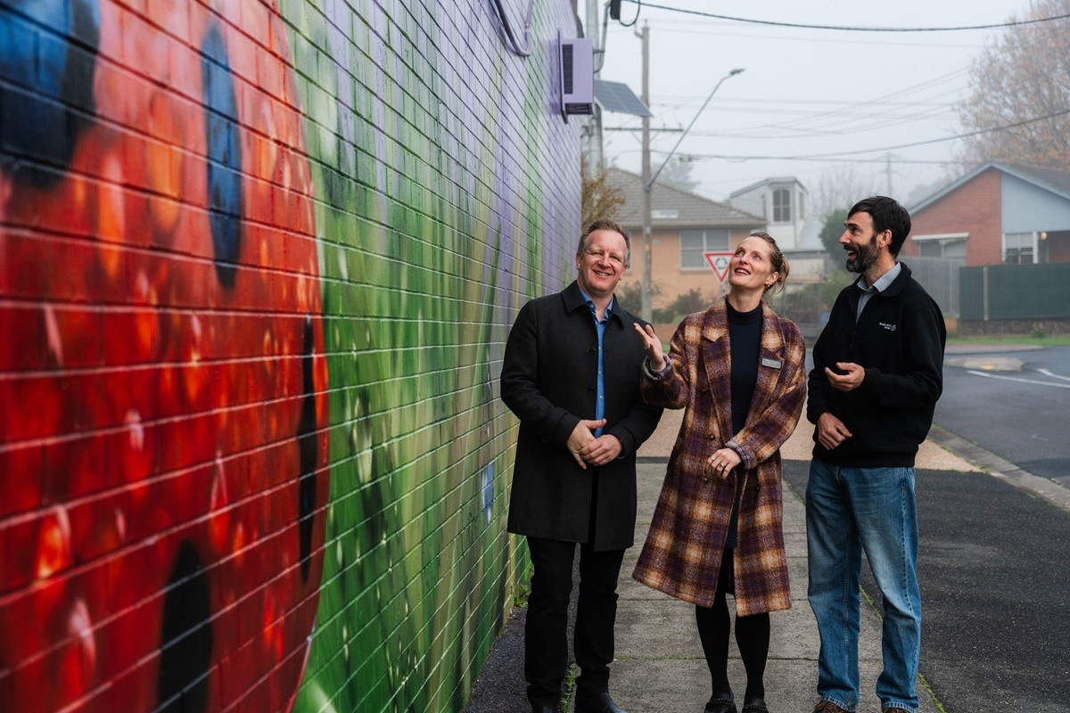 Three employees looking at the Frankston Monterey Mural.