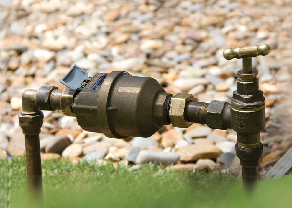Water meter installed over grass. 